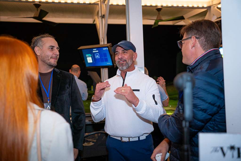 Paulo Paternes talking with guests at an evening networking event