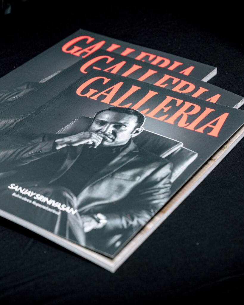 Three printed copies of the first Galleria issue fanned on black cloth, Sanjay Srinivasan on the cover.