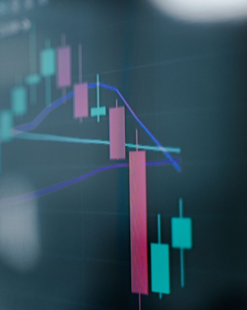 A close view of a candlestick chart on a trading screen, a long falling candle below the moving averages.