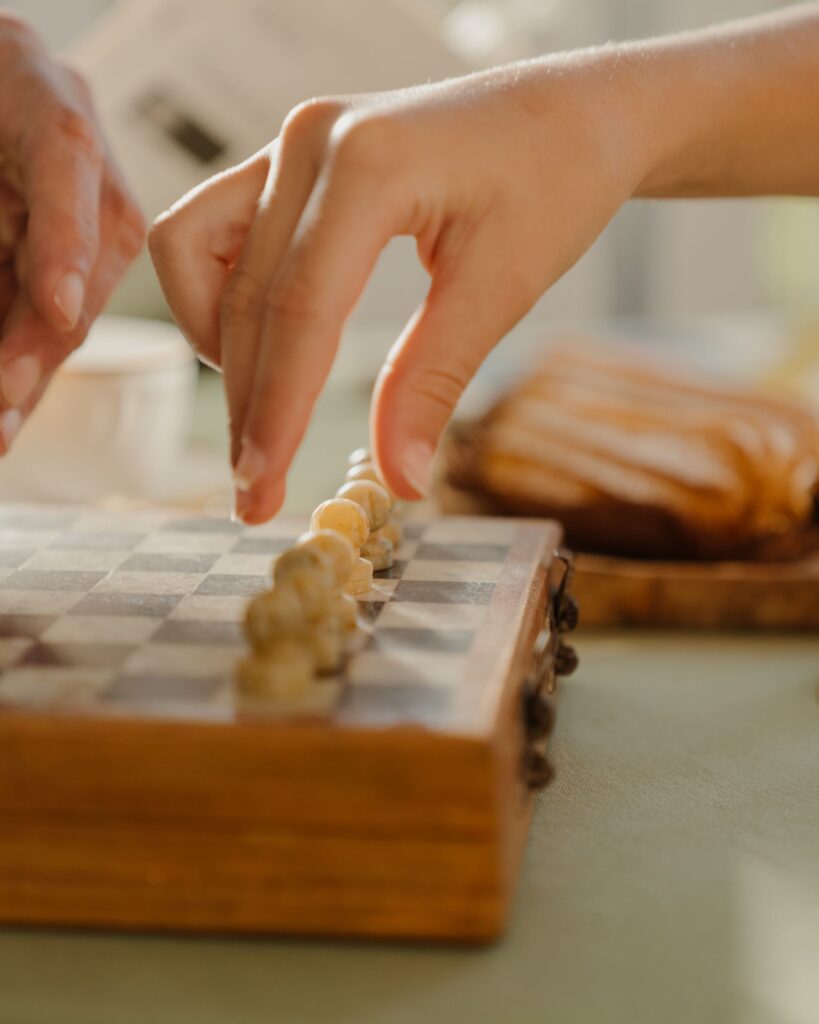 Two hands moving pieces across a small marble chessboard